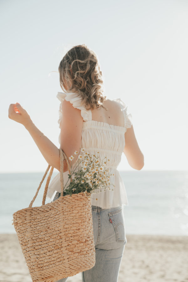 photographer on beach bag with flowers