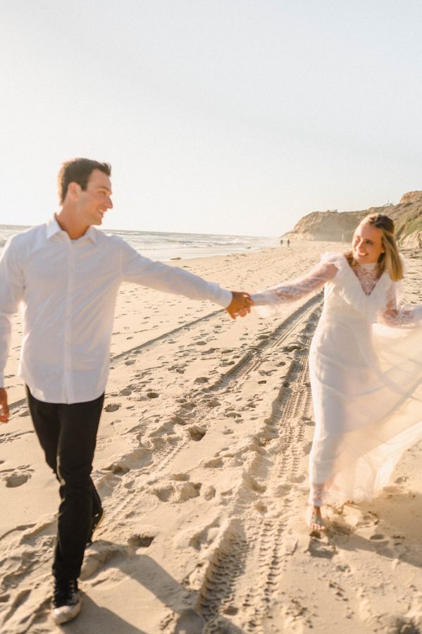 wedding couple holding hands beach