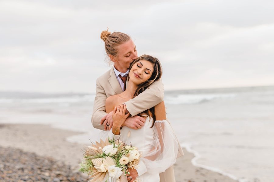 bride and groom kiss beach