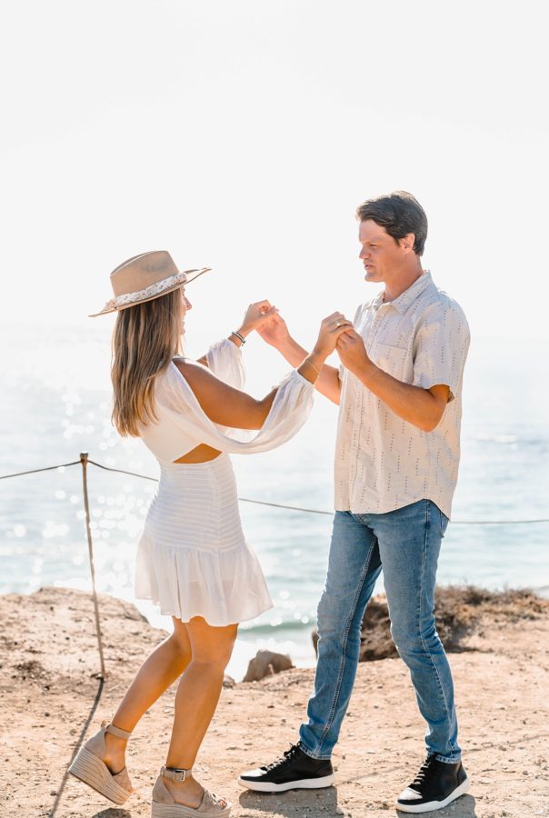 couple holding hands beachside