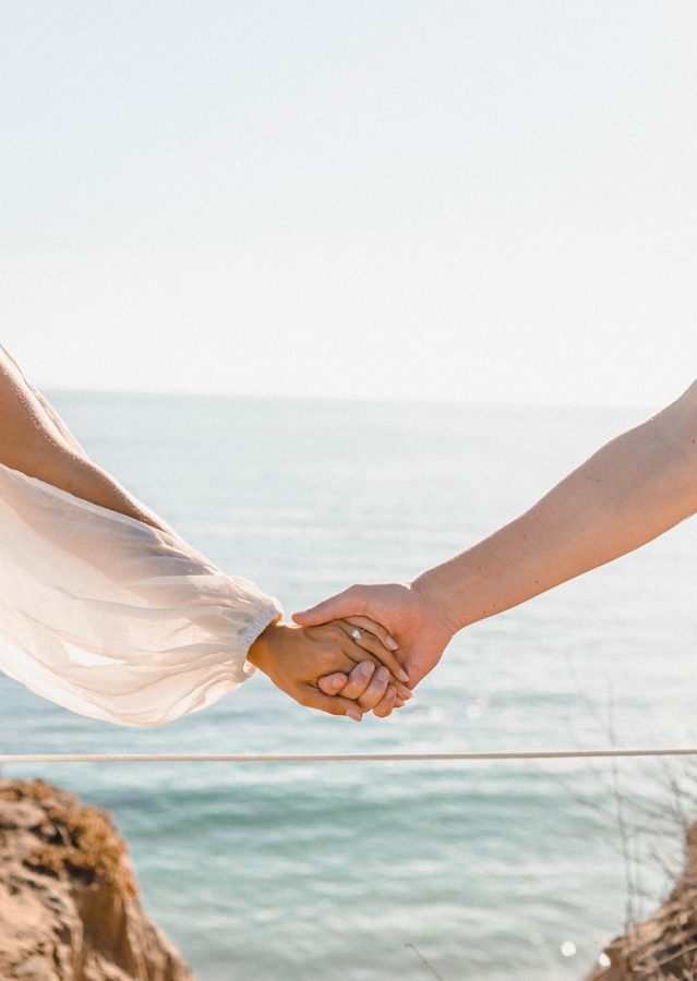 holding hands engagement ring ocean background