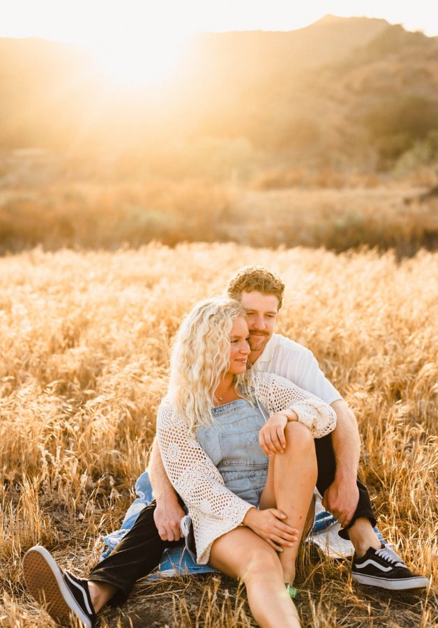 couple sitting golden hour smiling