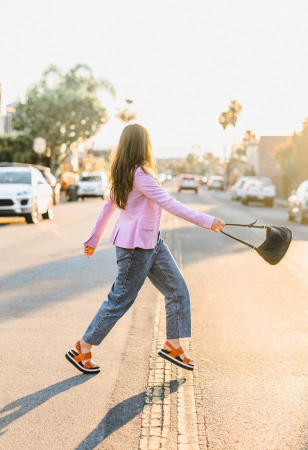 girl walking across street purse
