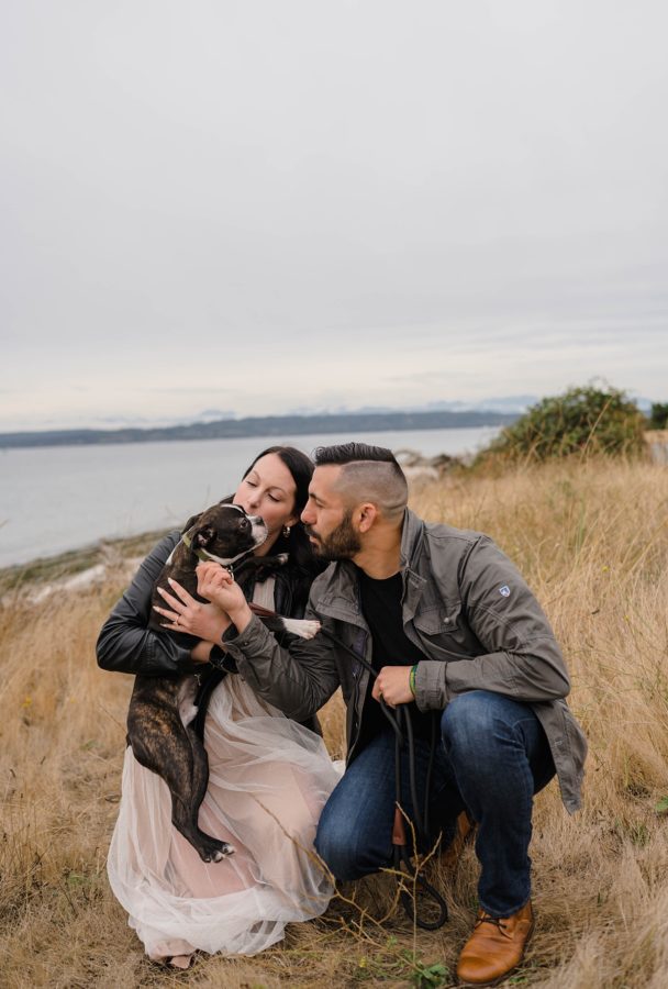 engaged couple hugging dog fall waterfront