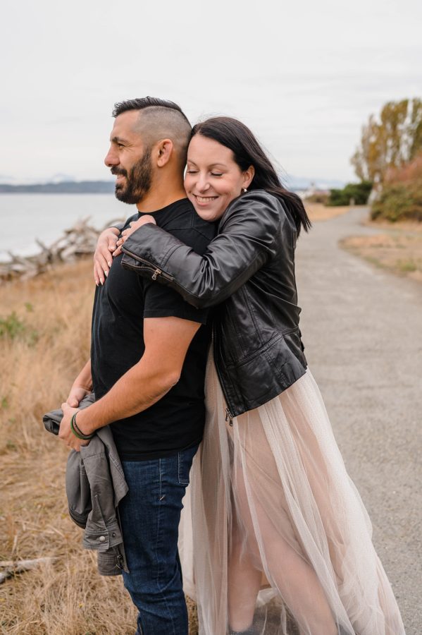 couple smiling hugging fall engagement