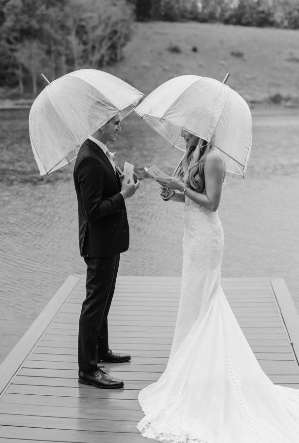 bride and groom private vow reading dock clear umbrellas black and white