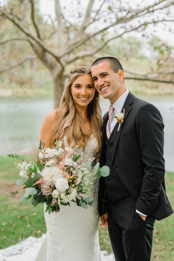 bride and groom portrait muted pink and green fall tones smiling together
