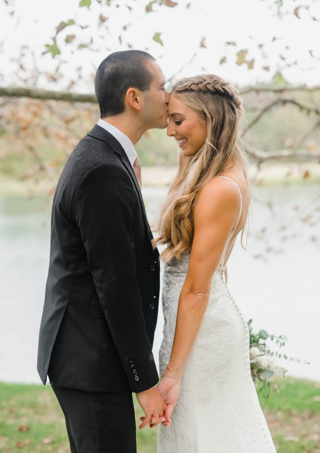 groom kissing bride on forehead lake overlook big spring farm wedding