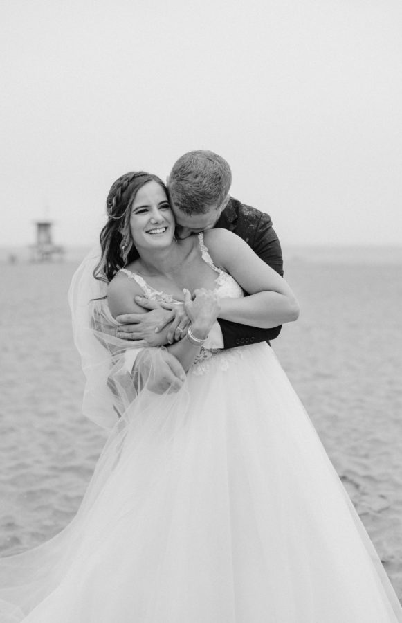 black and white beach bride and groom hugging smiling