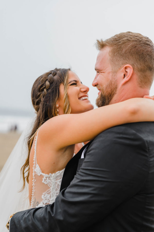 first-look wedding day bride and groom hugging smiling bridal details