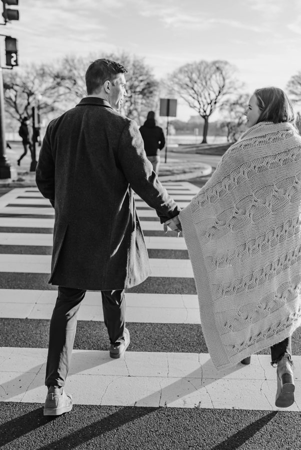 engaged couple walking holding hands cozy blanket