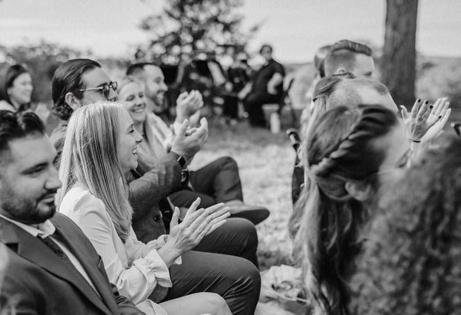 black and white wedding ceremony guests clapping and smiling