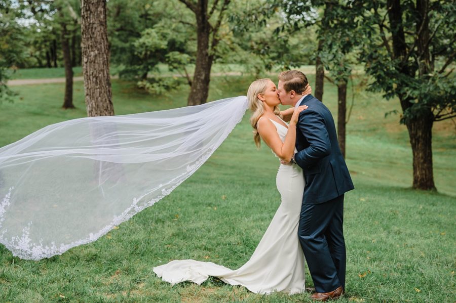 bride and groom kissing veil blowing