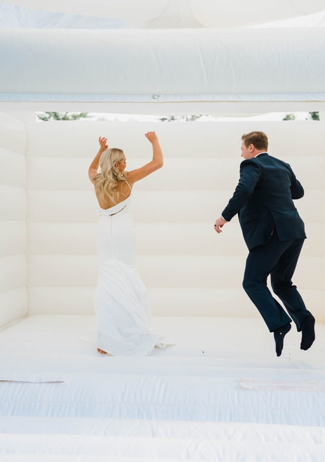 bride and groom jumping bounce house