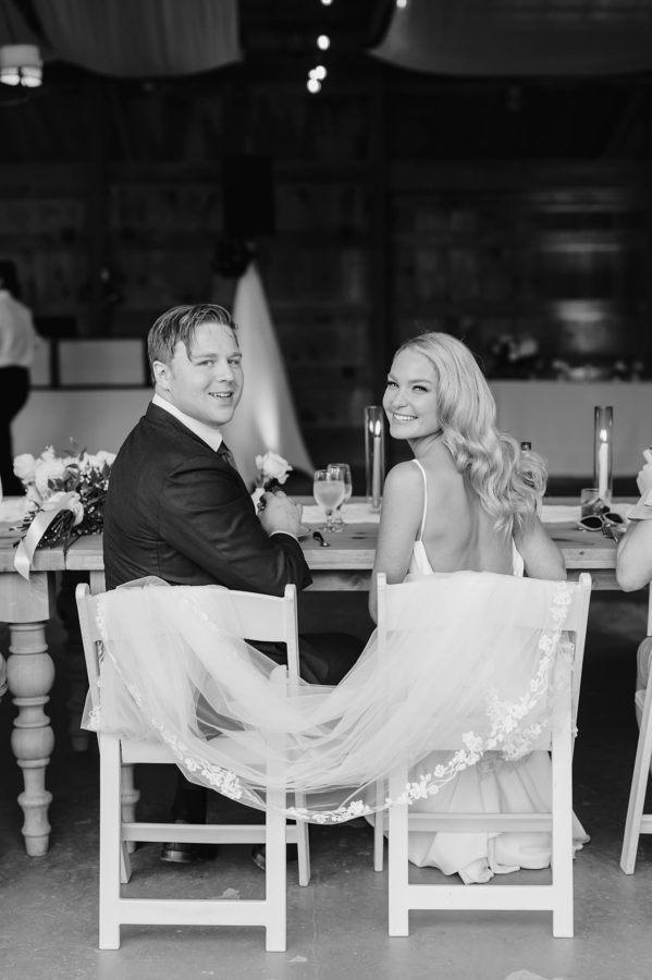 black and white destination wedding portrait bride and groom seated smiling