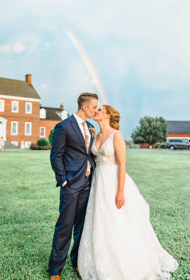 bride and groom kissing sunset rainbow