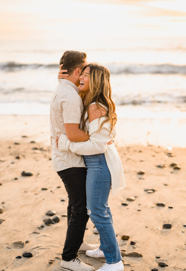 calafia beach engagement couple hugging smiling golden hour