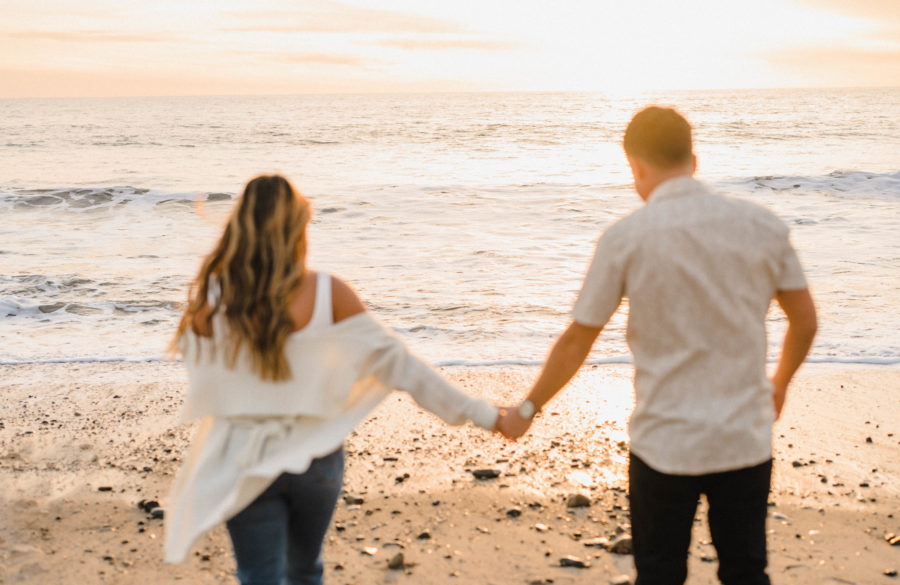 couple holding hands calafia beach foreground blur golden hour