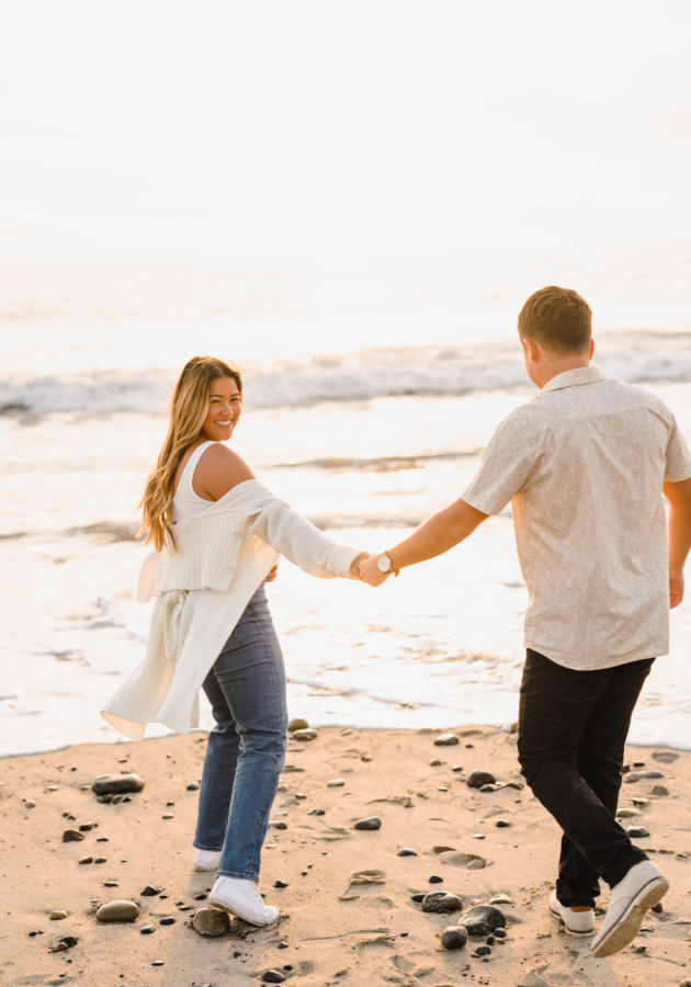 calafia beach engagement couple holding hands girl smiling golden hour