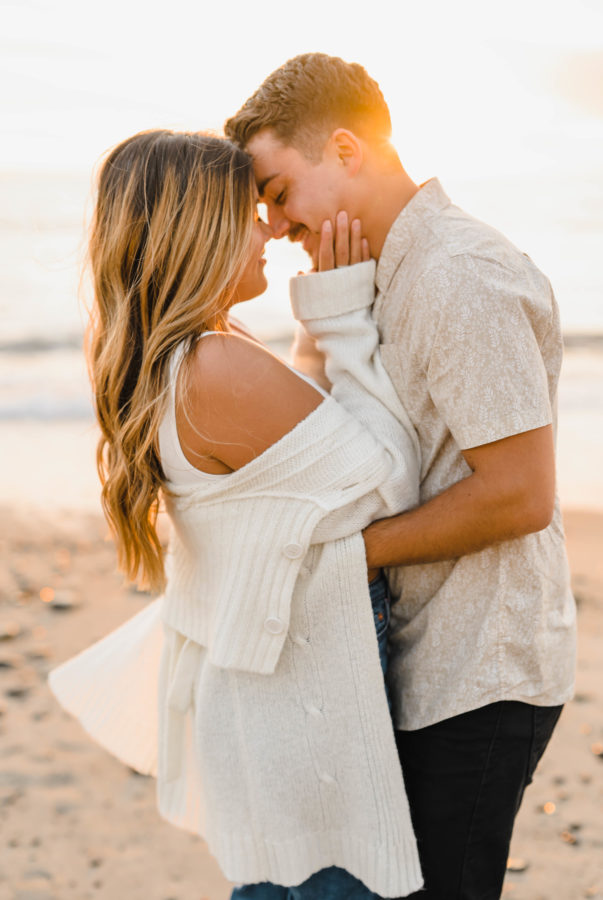engaged couple hugging smiling close golden hour