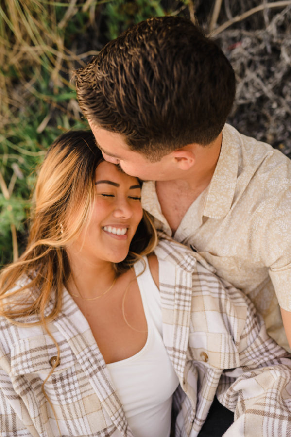 calafia beach engagement guy kissing girl smiling neutral tones outifits