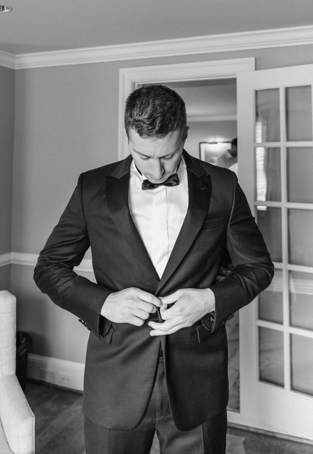 black and white groom getting ready tux bowtie