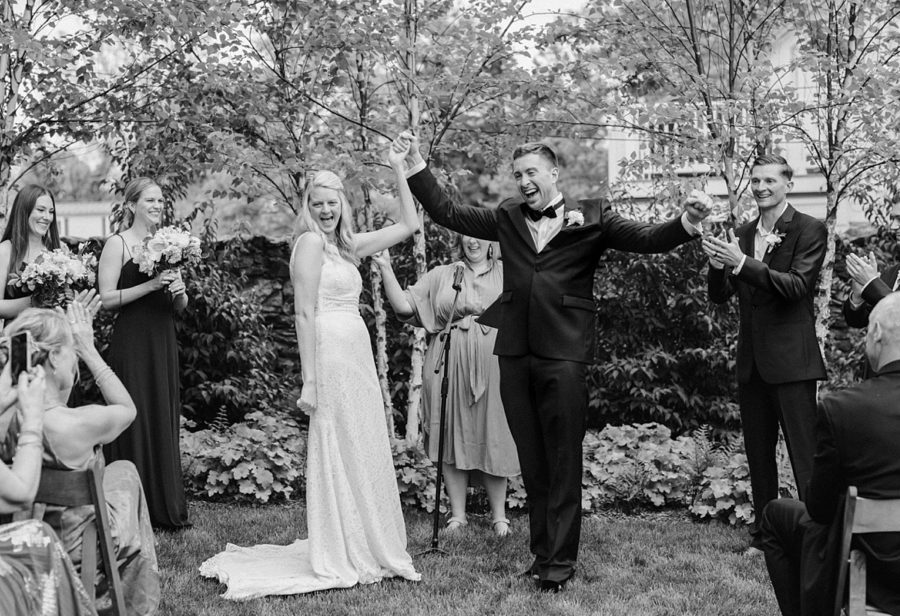 black and white middleburg garden wedding bride and groom holding hands smiling celebrating