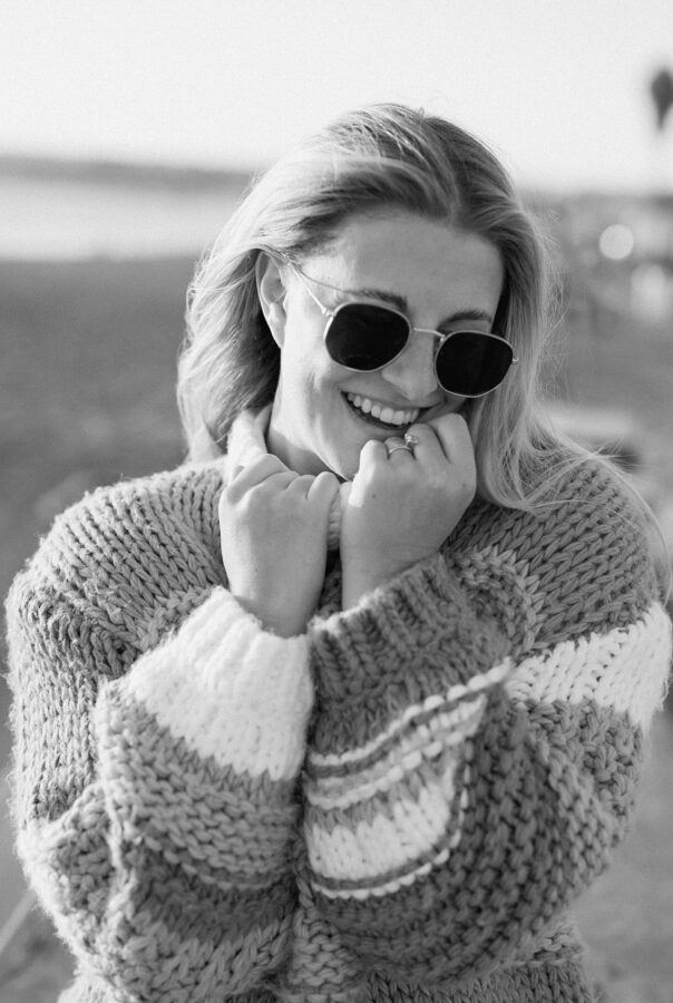 girl in sweater smiling big