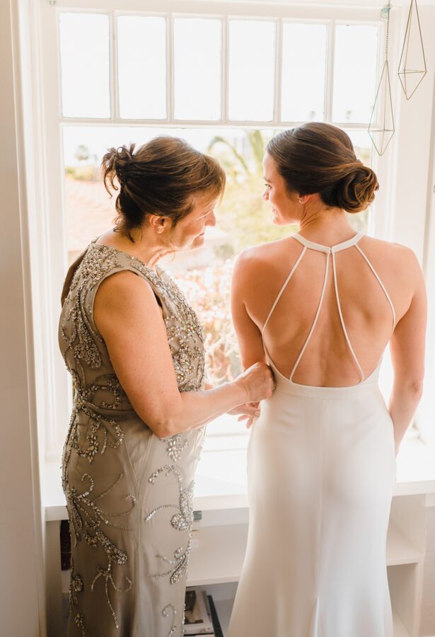 mom zippering brides dress